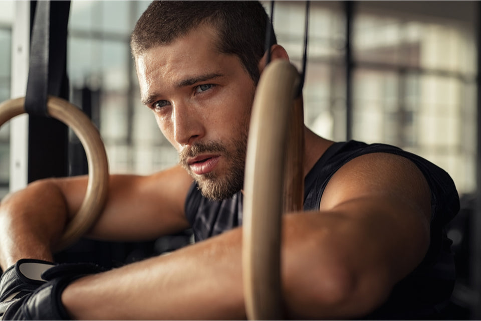 Man resting on gym rings